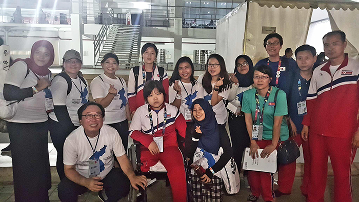  
Supporters of the 2018 Asian Para Games from the Korean Cultural Center Indonesia pose for a photo together with both South Korean officials and North Korean athletes. 
